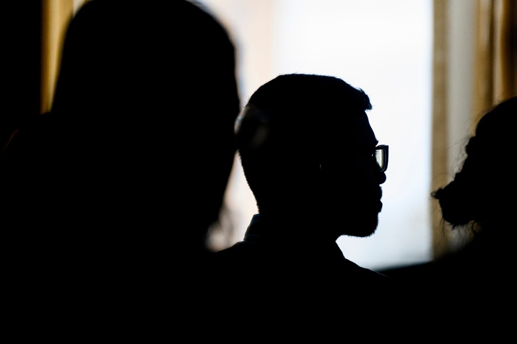 Silhouette of a person wearing glasses.