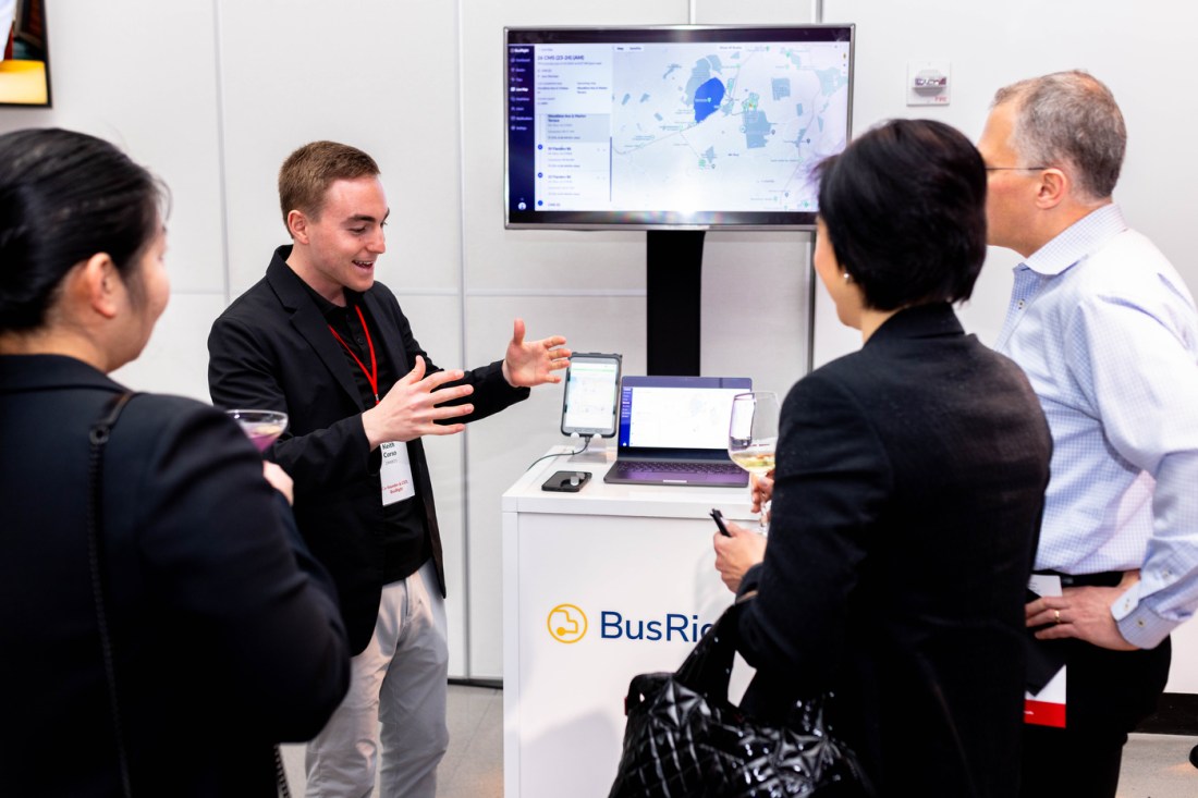 Founder of BusRight demonstrates the software on a laptop while gesturing with his hands. 