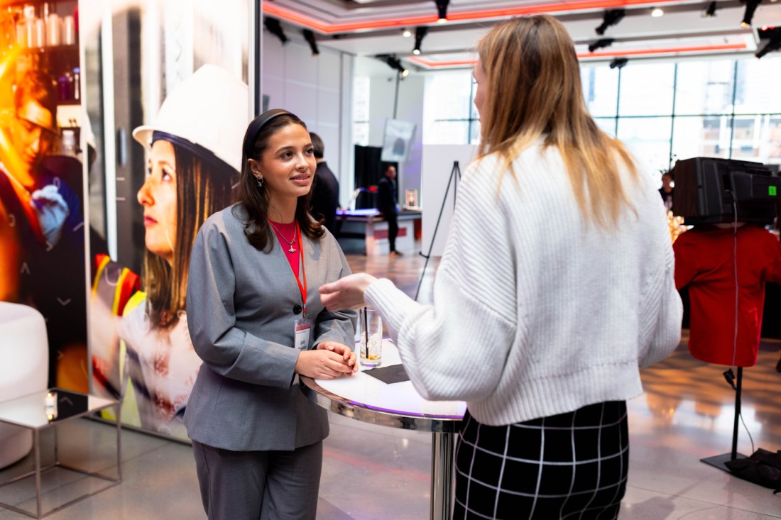 Two people having a conversation at the Experience Powered by Northeastern event. 