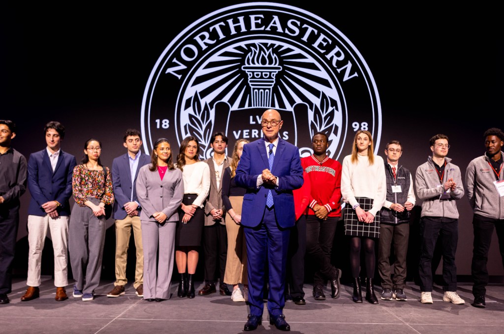 President Aoun standing on stage in front of groups of people.