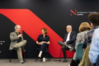 A panel of people sitting in front of a Northeastern branded backdrop.