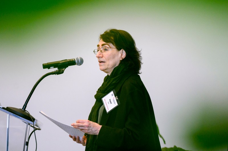 Hazel Sive speaking into a microphone at the Barnett Institute 50th Anniversary.