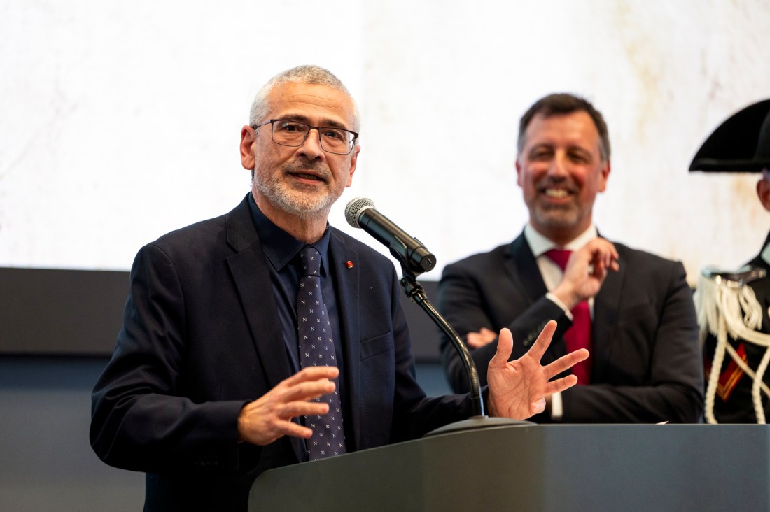 Alessandro Vespignani speaking to the crowd through a microphone.