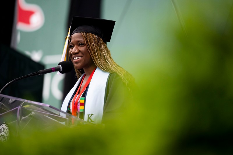 Rebecca Bamidele standing at the podium smiling. 