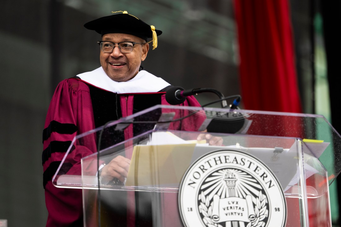 David Thomas in regalia speaking at the podium during the 2024 Commencement ceremony