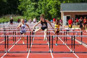 Dominique Beron jumping over a hurdle.