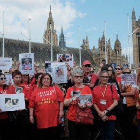 Protestors assembled at Parliament Square carrying signs and wearing red t-shirts.