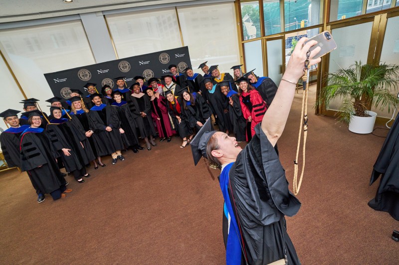 A faculty member taking a selfie with other faculty members.