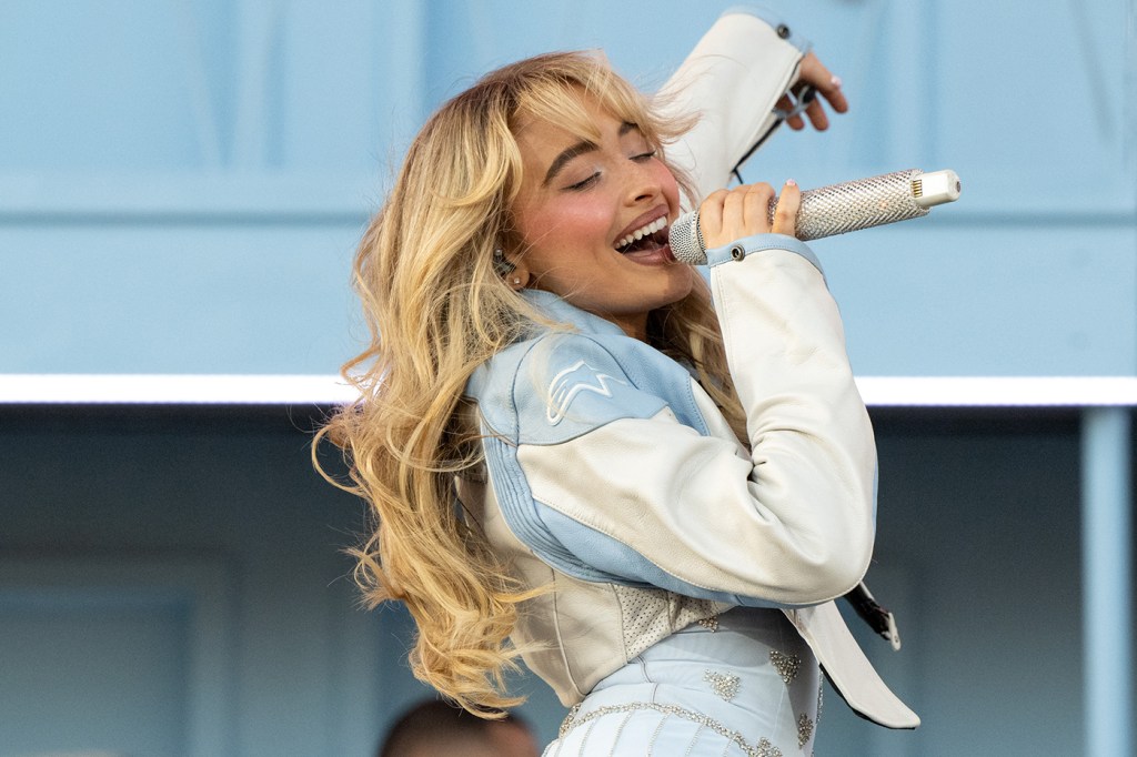 Sabrina Carpenter performs onstage while wearing a denim jacket and skirt.