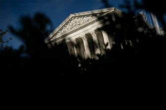 The Supreme Court Building in Washington DC partially blocked by the shadow of a plant.