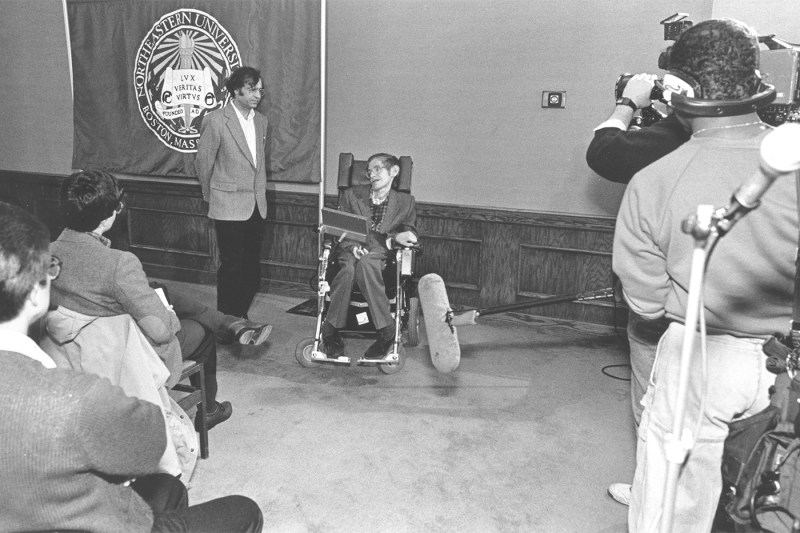 A black and white photo of Pran Nath standing next to Stephen Hawking.