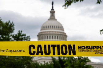 A photo of the Capitol with yellow caution tape outside of it.