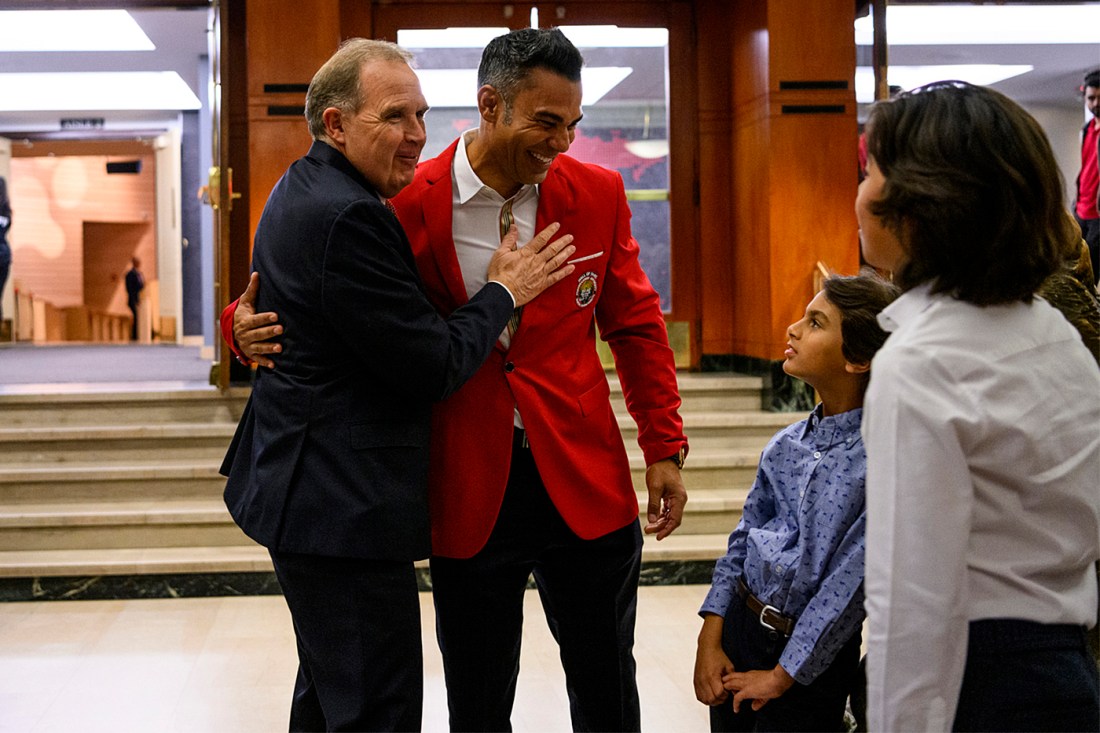 Jim Madigan with one arm around Carlos Pena's back and the other placed on his chest while both men smile.