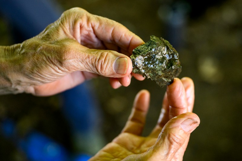 Hands hold an artifact discovered during an archeological dig. 