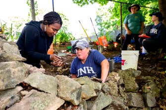 Kabria Baumgartner and a UNH researcher digging.