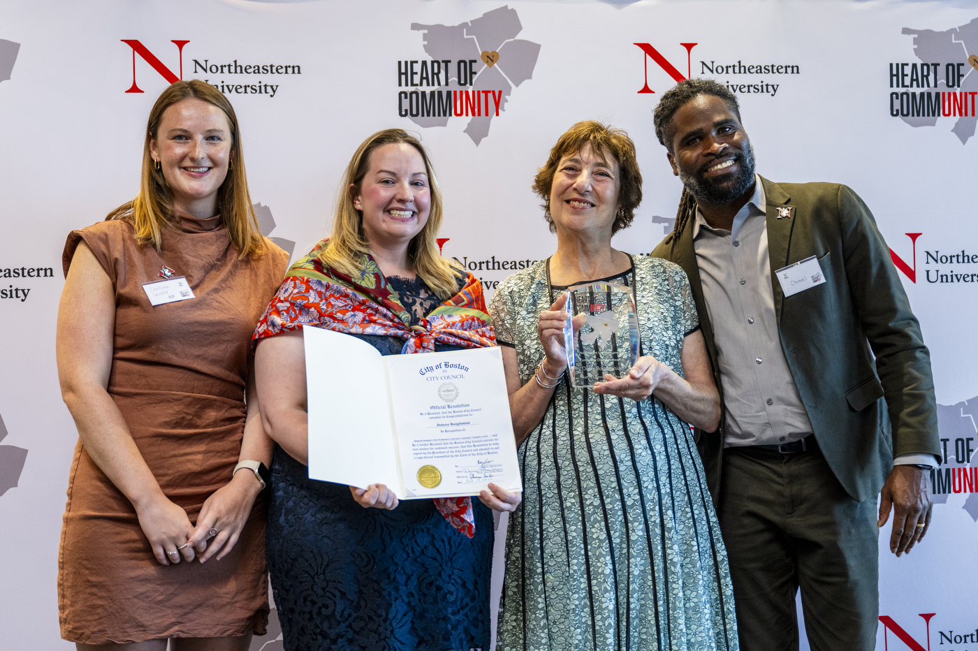 Four people posing together with an award.