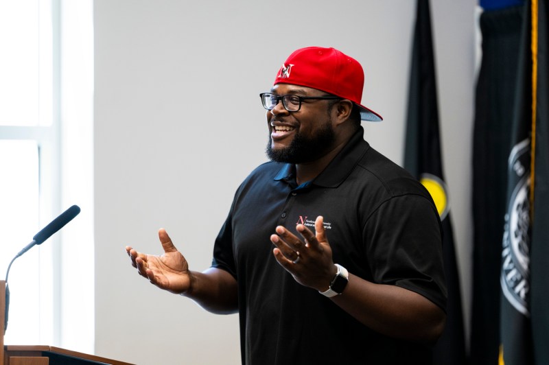 A panelist in a backwards red hat speaking at Northeastern's 2024 Juneteenth Celebration.