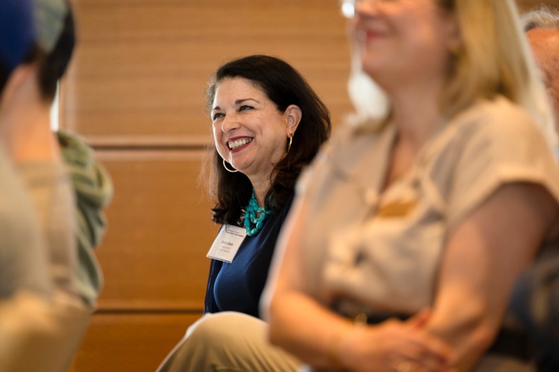 An audience member smiling at the fireside chest with chess grandmaster Garry Kasparov.