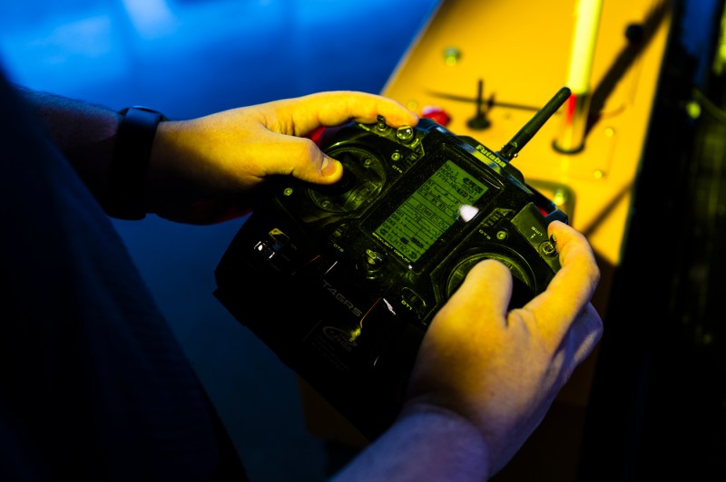 Hands hold a robotic controller that powers an Amazon machine.