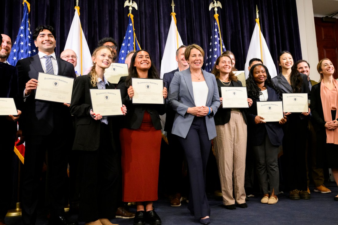 Students holding certificates stand around Gov. Maura Healey.