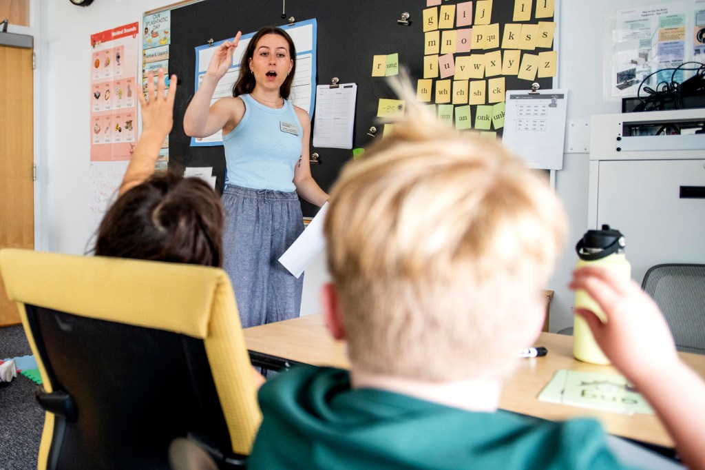 A teacher in a classroom calling on one of the students.