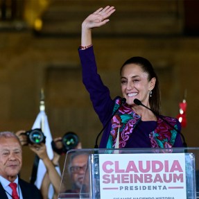 Claudia Sheinbaum standing at a podium waving.