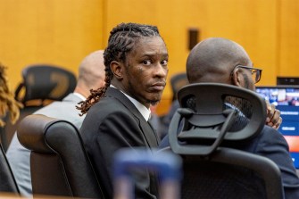 Young Thug faces a camera during his trial in a courtroom.