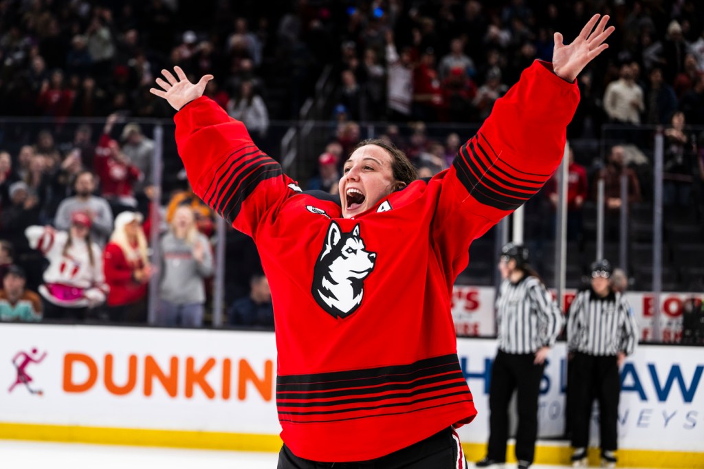 Gwyneth Philips with both arms up on the hockey rink.