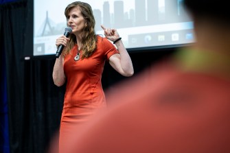 Northeastern professor Alicia Modestino speaks into a microphone to the Northeastern Summer Youth Jobs Program orientation in the Cabral Center.