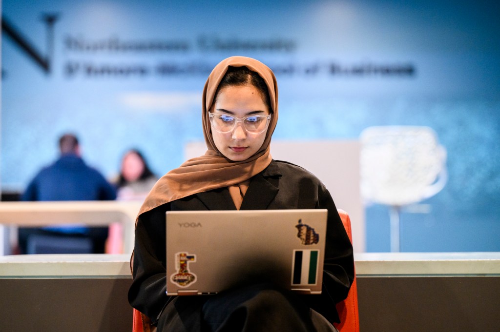 A person is sitting working on their laptop.