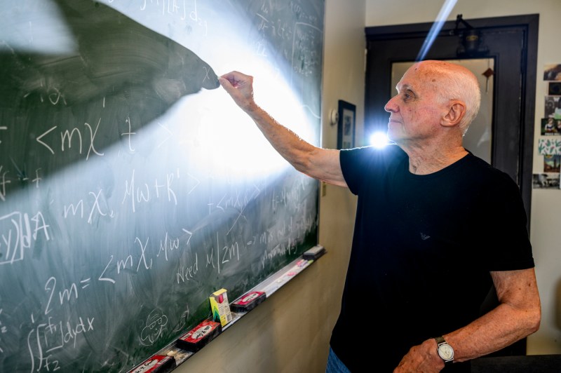 Solomon Jekel solving math problems on a chalkboard.