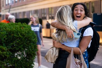 Two friends greeting each other with a big hug.