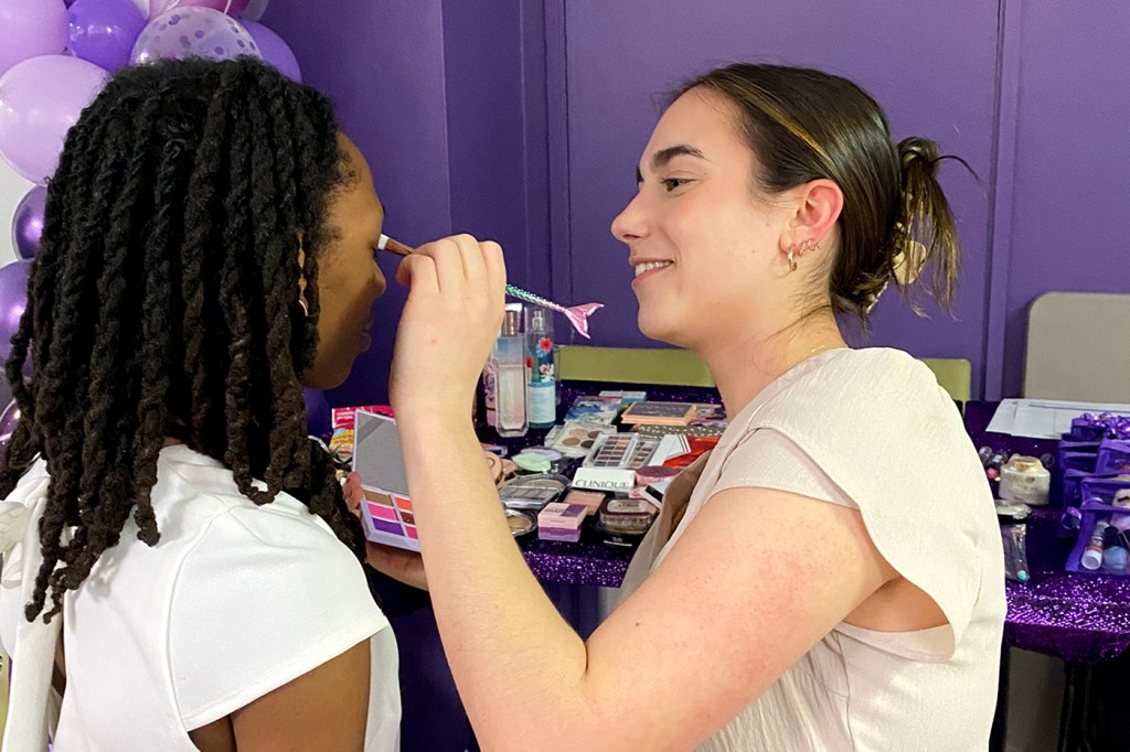 Someone doing makeup on someone else.