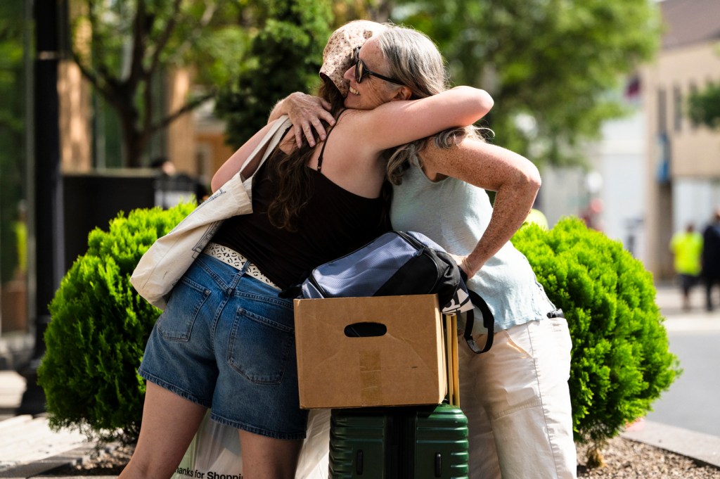 A student hugging their family.