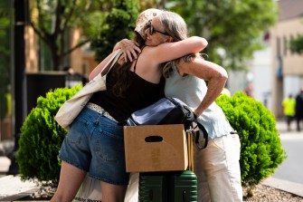 A student hugging their family.