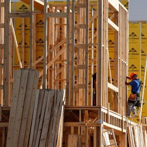 A worker building a home under construction.