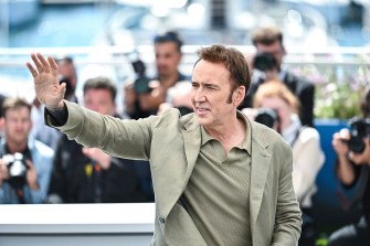 Nicolas Cage waving at paparazzi.