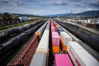 Shipping containers and rail cars at a rail yard in Canada.