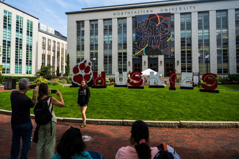 A student poses for a picture in front of the welcome week banner