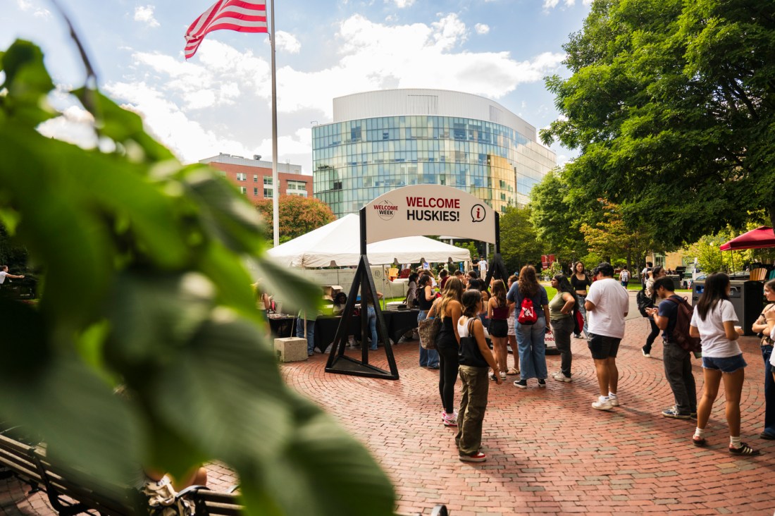 People walk through Northeastern's Welcome Week events outside on a sunny day.