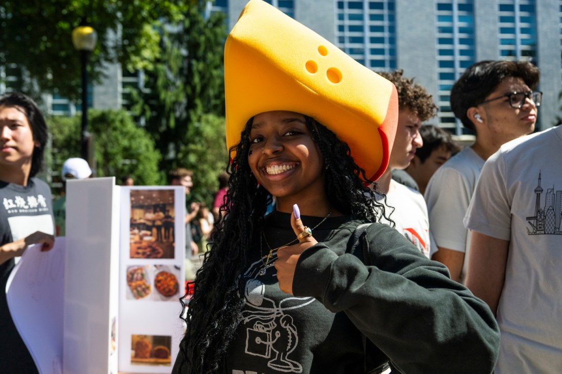 A student wearing a hat shaped like a triangle of cehese.