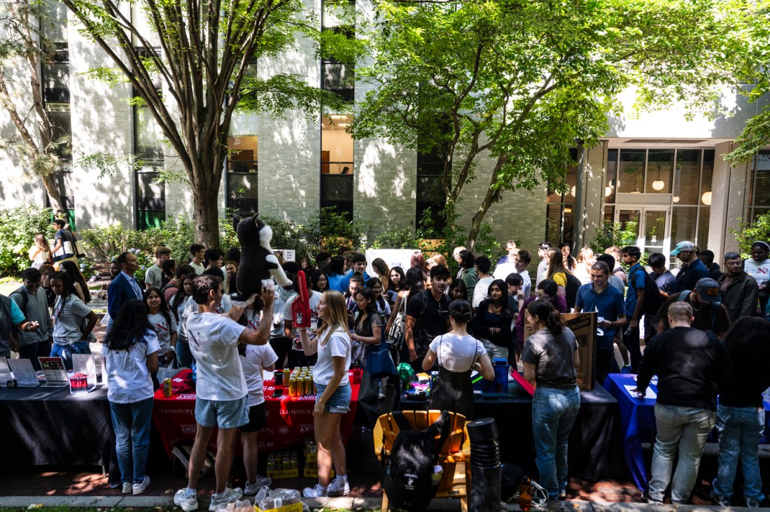 A crowd of students walking up to tables at Fall Fest.