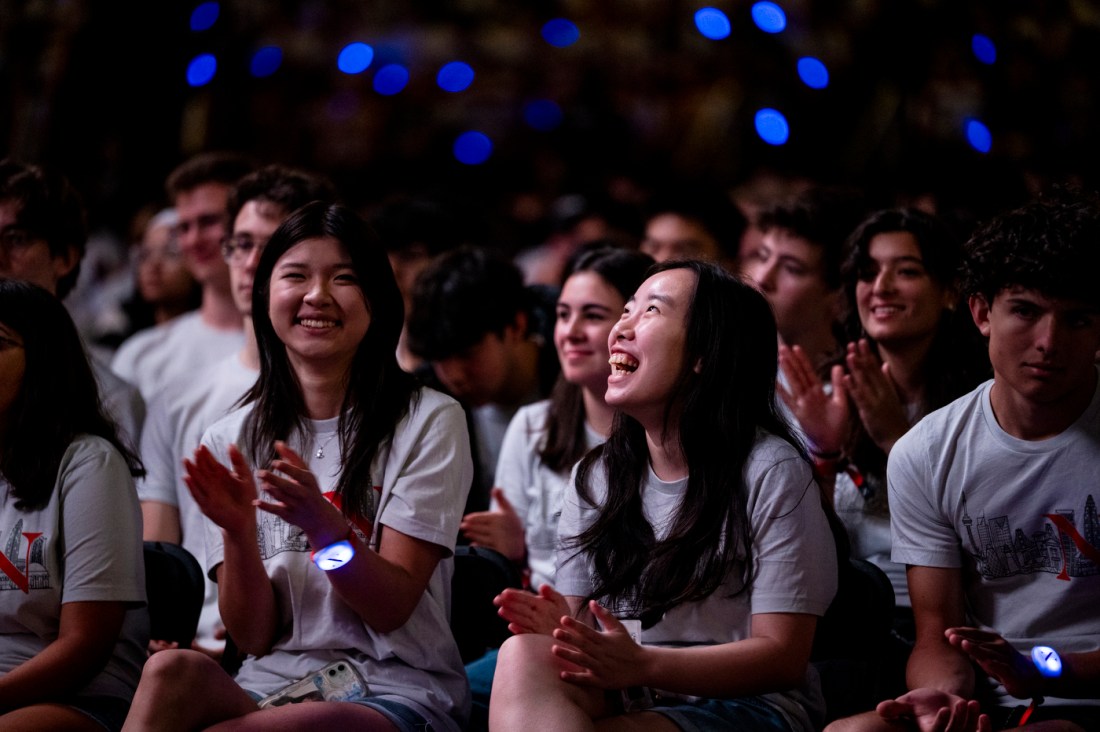 Audience members clapping and smiling at Convocation.