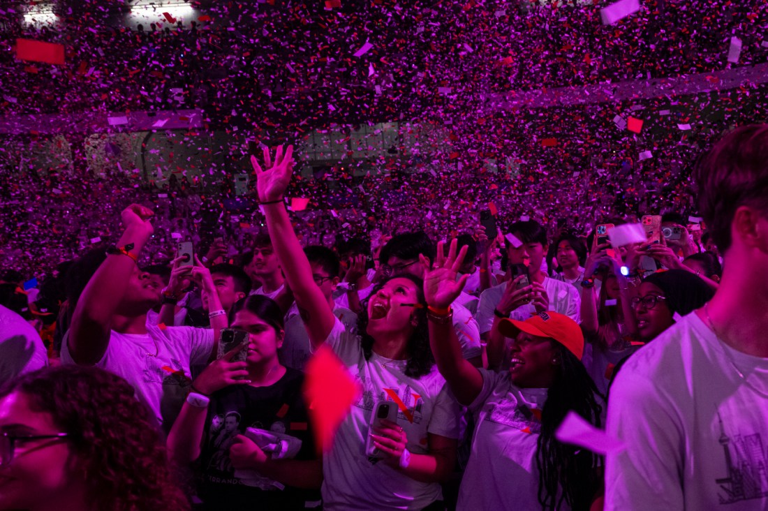 Students with their hands in the air as confetti falls around them at Convocation.