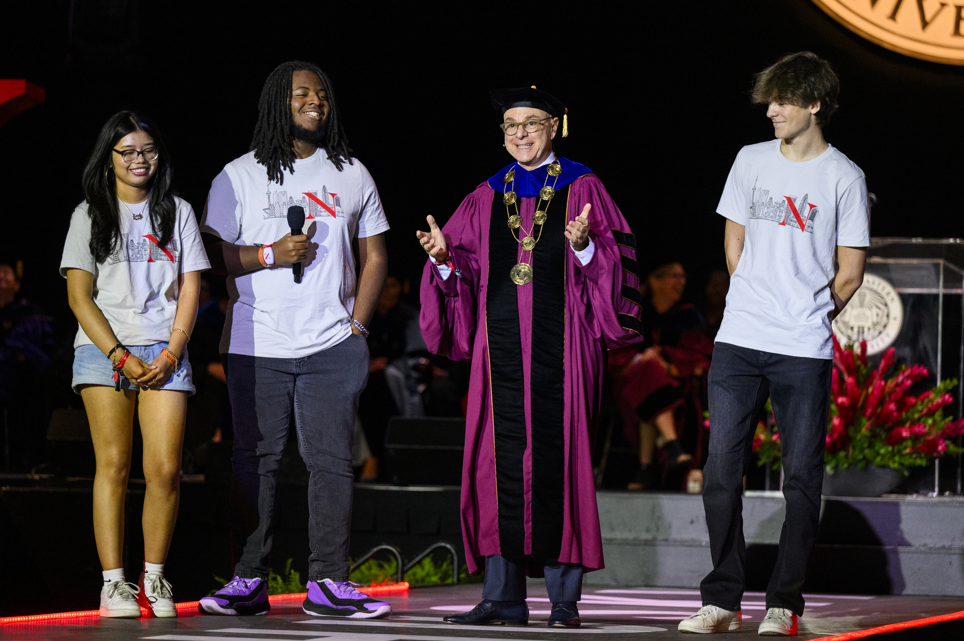 President Aoun smiling and gesturing on stage at Convocation.