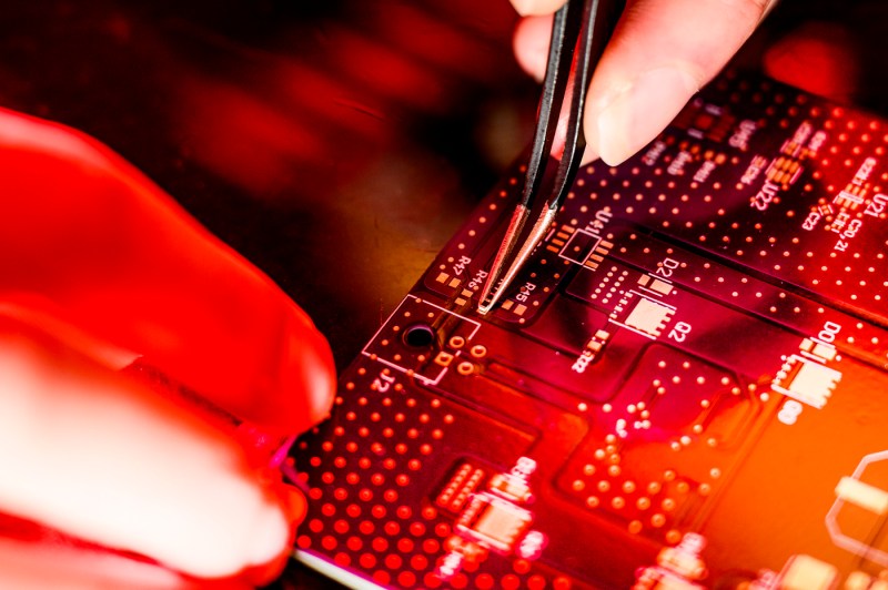 A student working on a test panel with tweezers. 