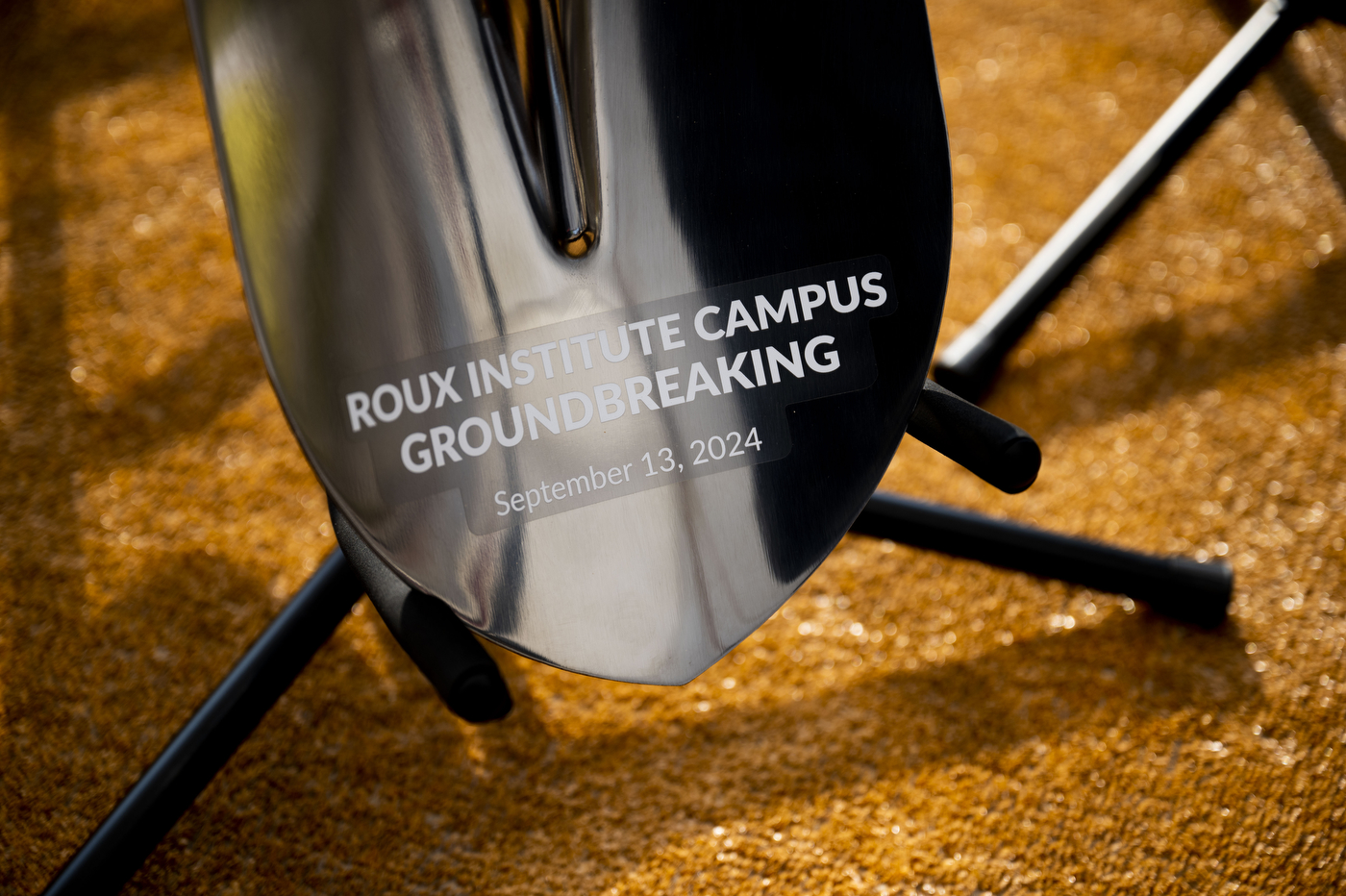 A silver shovel that says 'Roux Institute Campus Groundbreaking September 13, 2024'. 