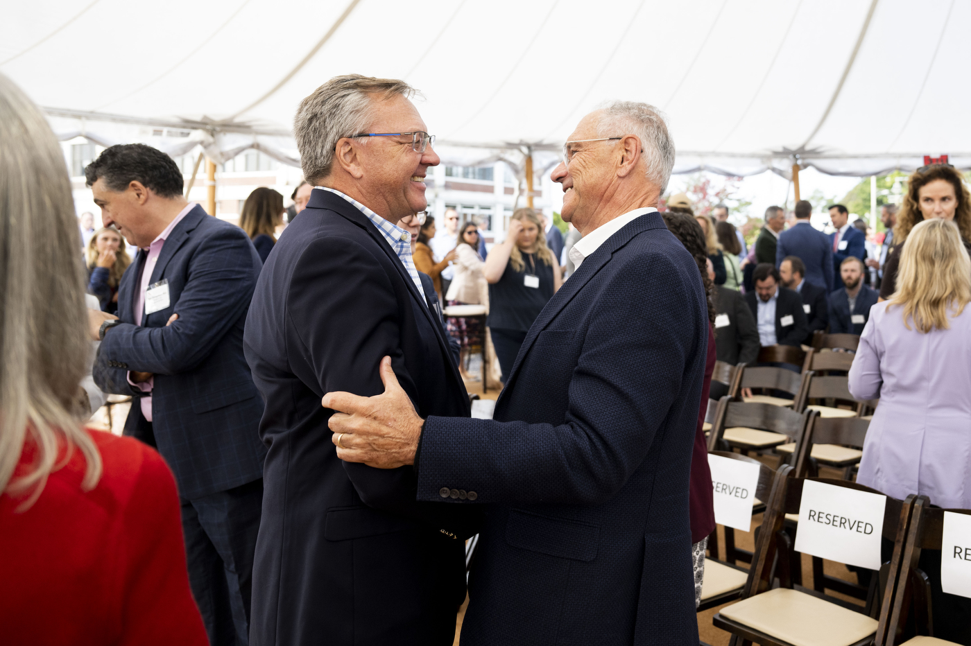 Two people greeting each other at the Portland ground breaking. 