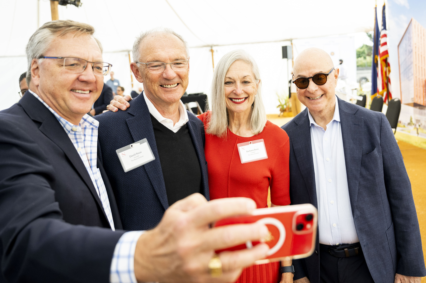 A person takes a selfie with David and Barbara Roux and President Aoun. 