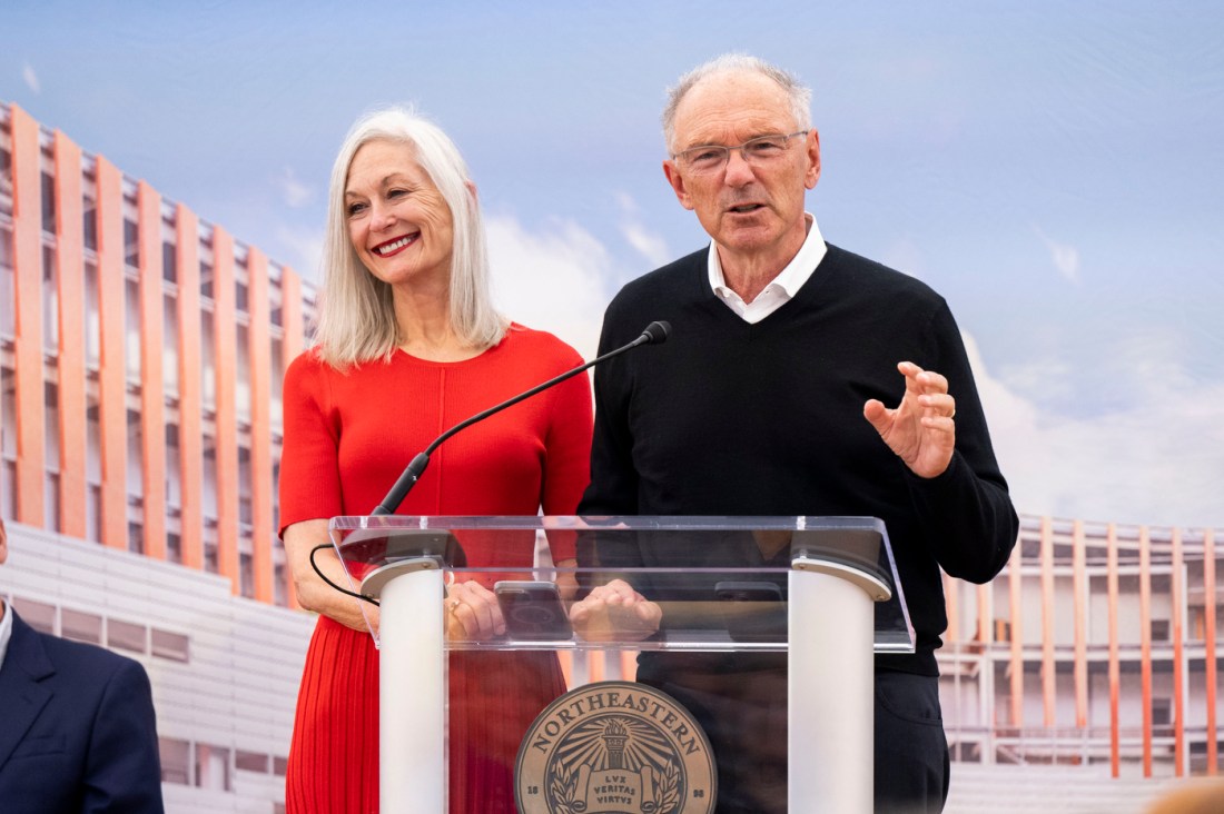 David and Barbara Roux speaking at a podium at the Portland ground breaking. 